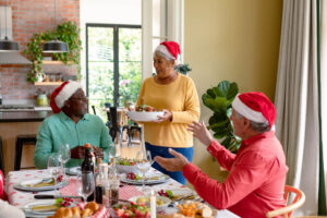 group of happy senior friends with Santa hats on
